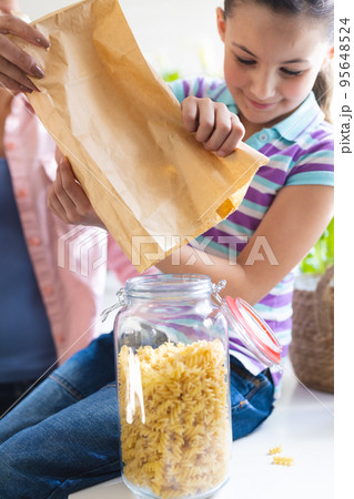 Vertical picture of mother and daughter spending time together in the kitchen 95648524