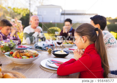 Happy caucasian family spending time together and praying before meal in the garden Happy caucasian family spending time together and praying before meal in the garden 95648577