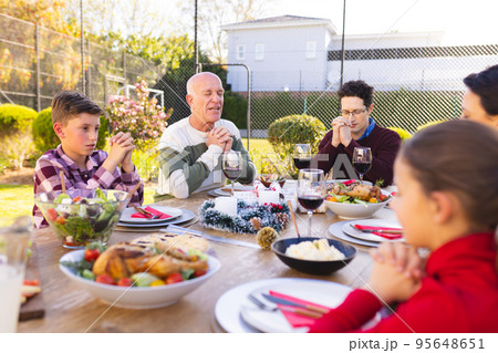 Happy caucasian family spending time together and praying before meal in the garden Happy caucasian family spending time together and praying before meal in the garden 95648651