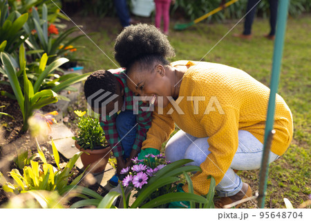 African american mother and son spending time together in the garden and gardening African american mother and son spending time together in the garden and gardening 95648704