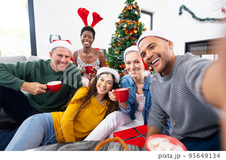 Image of happy diverse friends celebrating christmas at home taking selfie Image of happy diverse friends celebrating christmas at home taking selfie 95649134