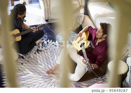 young asian adult men rock band members rehearsing singing playing musical instruments in a house young asian adult men rock band members rehearsing singing playing musical instruments in a house 95649287