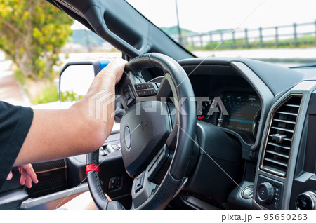 車を運転する男性の手元イメージ｜左ハンドル車 95650283