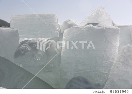 Transparent blue ice hummocks on lake Baikal shore. Siberia winter landscape view. Snow-covered ice of the lake 95651946
