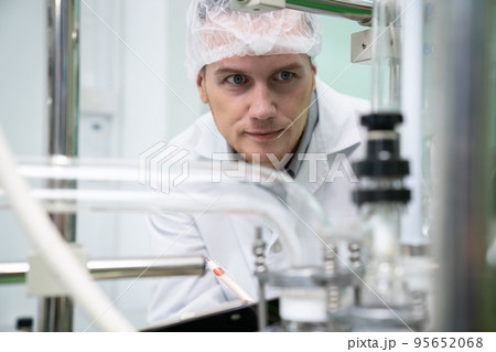 Portrait of a scientist, apothecary extracting cannabis oil in laboratory. Portrait of a scientist, apothecary extracting cannabis oil in laboratory. 95652068