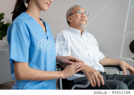 Caring nurse and a contented senior man in a wheel chair at home. 95652196