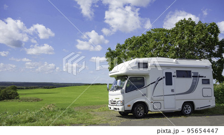 北海道の平原の牧草地を背景にするキャンピングカー 95654447