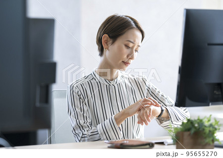 仕事中に時間が気になる女性　ワーキングマザー 95655270