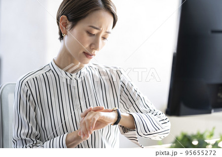 仕事中に時間が気になる女性　ワーキングマザー 95655272