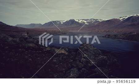 Atmospheric landscape with mountain lake among moraines in rainy weather 95656119