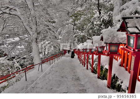 雪の貴船神社本宮で、滑り落ちそうな灯籠階段を見下ろす 95656365