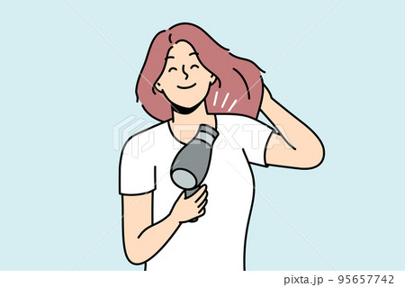 Smiling woman blow hair with fan  95657742