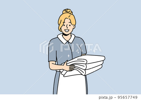 Smiling housekeeper with stack of towels Smiling housekeeper with stack of towels 95657749