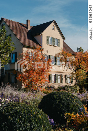 House with nice garden in fall. Flowers in the City Park of Bietigheim-Bissingen, Baden-Wuerttemberg, Germany, Europe. Autumn Park and house, nobody, bush and grenery House with nice garden in fall. Flowers in the City Park of Bietigheim-Bissingen, Baden-Wuerttemberg, Germany, Europe. Autumn Park and house, nobody, bush and grenery 95662042