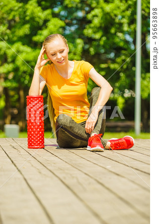 Girl doing exercises outdoor, using roller Girl doing exercises outdoor, using roller 95663898