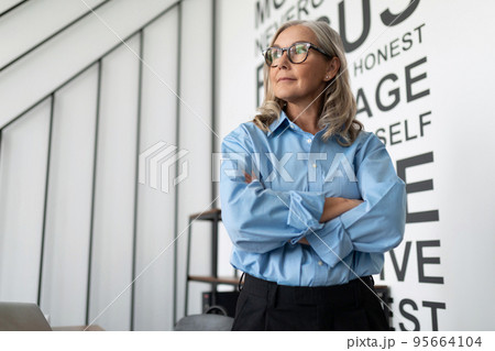 Middle aged older business woman looks intently to the side Well in the office, concept of Middle aged older business woman looks intently to the side Well in the office, concept of 95664104