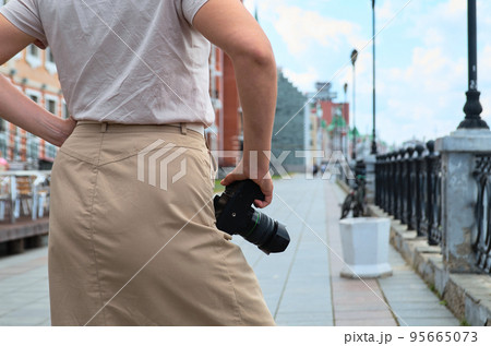 Woman tourist with photo camera on the city street Woman tourist with photo camera on the city street 95665073