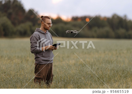 Man controlling a drone with a remote control 95665519