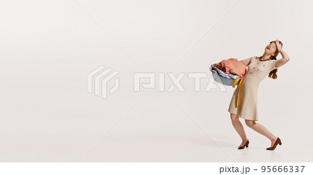 Portrait of young elegant woman washing clothes isolated over white background. Feeling tired Portrait of young elegant woman washing clothes isolated over white background. Feeling tired 95666337