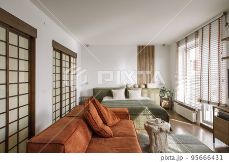 Modern Japandi appartment interior design in earth tones, natural textures with wooden solid oak furniture and sliding Japanese wood doors. Japandi concept 95666431
