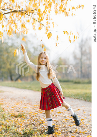 Autumn open portrait of a beautiful happy baby girl walking in a Park or forest. Charming happy girl playing with a tree branch. Autumn open portrait of a beautiful happy baby girl walking in a Park or forest. Charming happy girl playing with a tree branch. 95666543