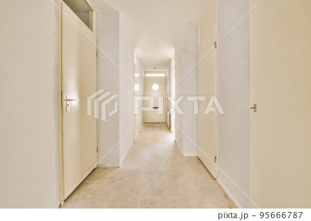 Light narrow hallway with many doors in white walls and glowing lamp over lumber floor Light narrow hallway with many doors in white walls and glowing lamp over lumber floor 95666787