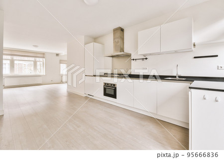 Interior of empty white kitchen with windows and wooden parquet floor Interior of empty white kitchen with windows and wooden parquet floor 95666836