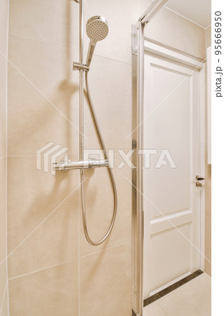 Sink with tap and liquid soap hanging on tiled wall under mirror in contemporary restroom at home 95666950