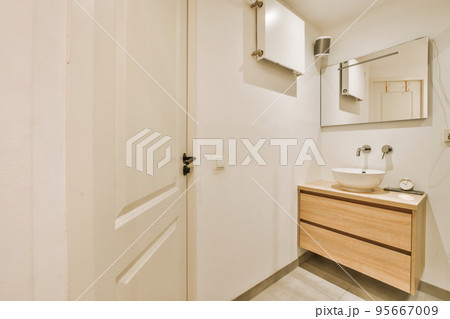 Sink with tap and liquid soap hanging on tiled wall under mirror in contemporary restroom at home Sink with tap and liquid soap hanging on tiled wall under mirror in contemporary restroom at home 95667009