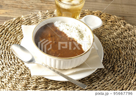 耐熱皿に盛られた熱々チーズカレーライスとお茶 95667796