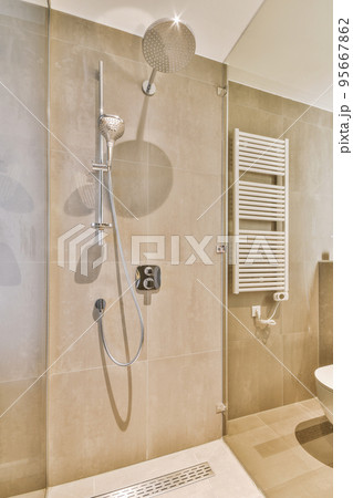 Bathroom with white tiled walls and open shower near sink base cabinet in light Bathroom with white tiled walls and open shower near sink base cabinet in light 95667862