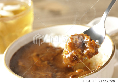 耐熱皿に盛られた熱々チーズカレーライスとお茶 95667900