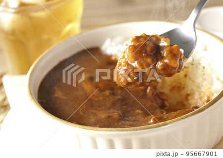 耐熱皿に盛られた熱々チーズカレーライスとお茶 95667901