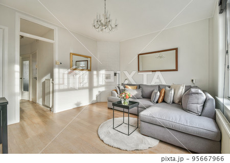 Square table placed on mat near couch and TV in stylish living room of contemporary apartment Square table placed on mat near couch and TV in stylish living room of contemporary apartment 95667966