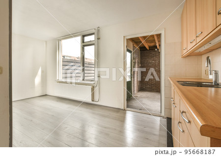 Interior of empty white kitchen with windows and wooden parquet floor Interior of empty white kitchen with windows and wooden parquet floor 95668187