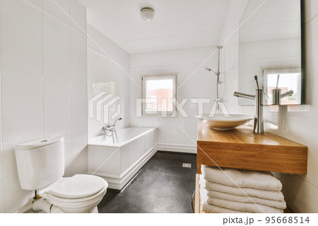 Flush toilet located between sink and shower in small tiled bathroom of contemporary apartment Flush toilet located between sink and shower in small tiled bathroom of contemporary apartment 95668514