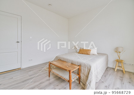 Comfortable bed and soft carpet in spacious bedroom with interior in minimal style 95668729