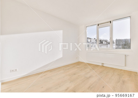 Plastic window and radiator on white wall in empty light room at home Plastic window and radiator on white wall in empty light room at home 95669167