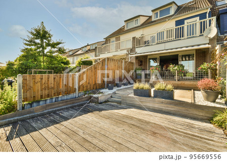 Neat paved patio with sitting area and small garden near wooden fence Neat paved patio with sitting area and small garden near wooden fence 95669556