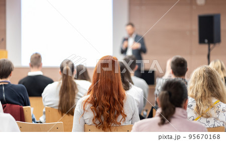 Speaker giving a talk in conference hall at business event. Rear view of unrecognizable people in audience at the conference hall. Business and entrepreneurship concept. Speaker giving a talk in conference hall at business event. Rear view of unrecognizable people in audience at the conference hall. Business and entrepreneurship concept. 95670168