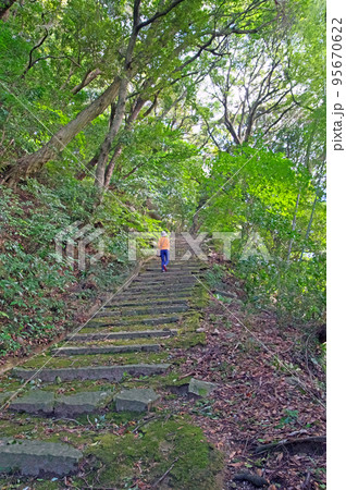 福岡県苅田町の里山等覚寺にある白山多賀神社参道を歩く人物 95670622