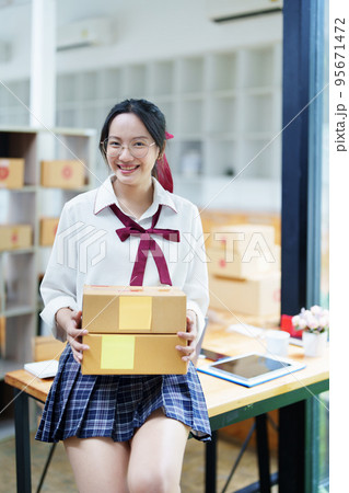 Starting small business entrepreneur of independent Asian woman smiling using computer laptop with cheerful success of online marketing package box items and SME delivery concept. 95671472