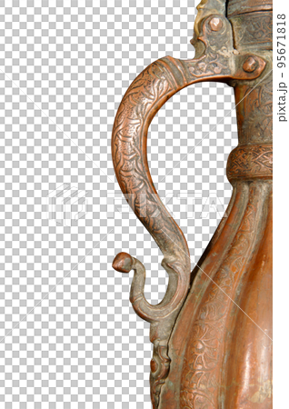 A close up of a handle of an antique copper jug with artistic chasing and engraving 95671818
