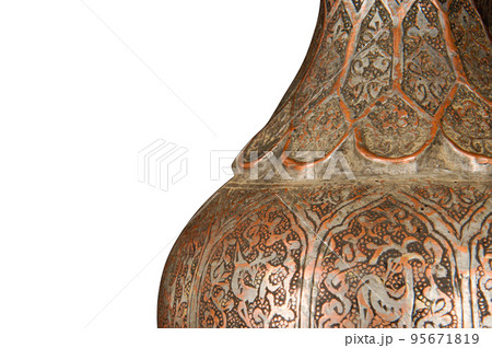 A part of an antique copper jug with artistic chasing and engraving on a white background 95671819