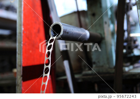 Perforated metal tape. Production of bearings. Equipment at the factory for production of bearings. Photos without people.Selective focus. 95672243