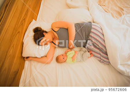 Mother and newborn baby sleep in the bed Mother and newborn baby sleep in the bed 95672606