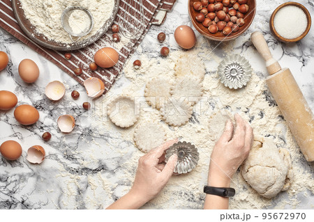 Close-up shot. Top view of a baker cook place, hands are working with a raw dough on the marble table background. 95672970