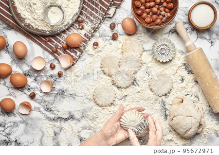 Close-up shot. Top view of a baker cook place, hands are working with a raw dough on the marble table background. 95672971