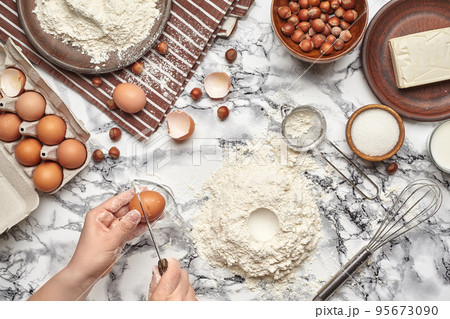 Close-up shot. Top view of a baker cook place, hands are working with a raw dough on the marble table background. 95673090