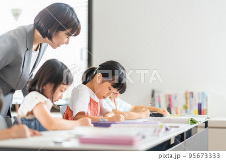 教室で勉強をする小学生と先生。 教室で勉強をする小学生と先生。 95673333